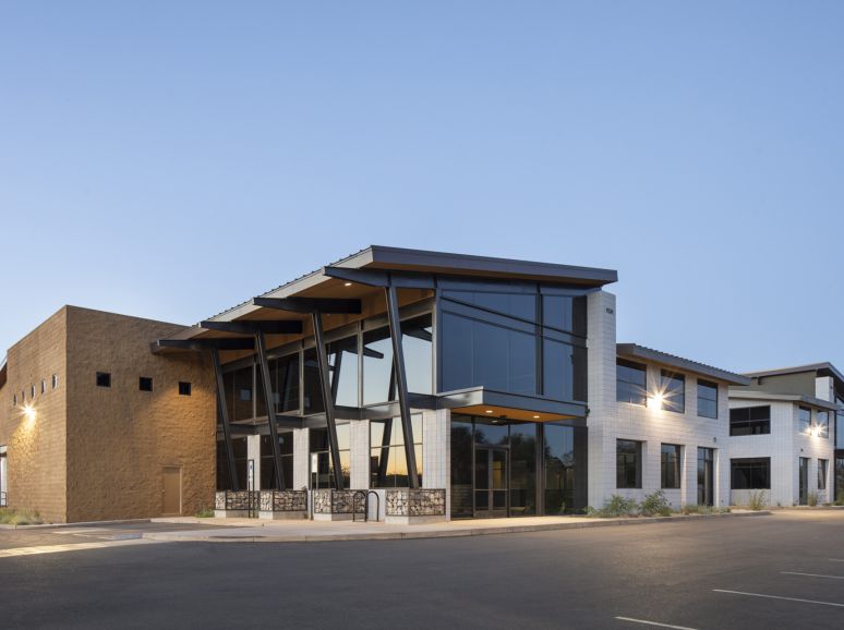 Two-storey commercial building with a steel canopy at dusk