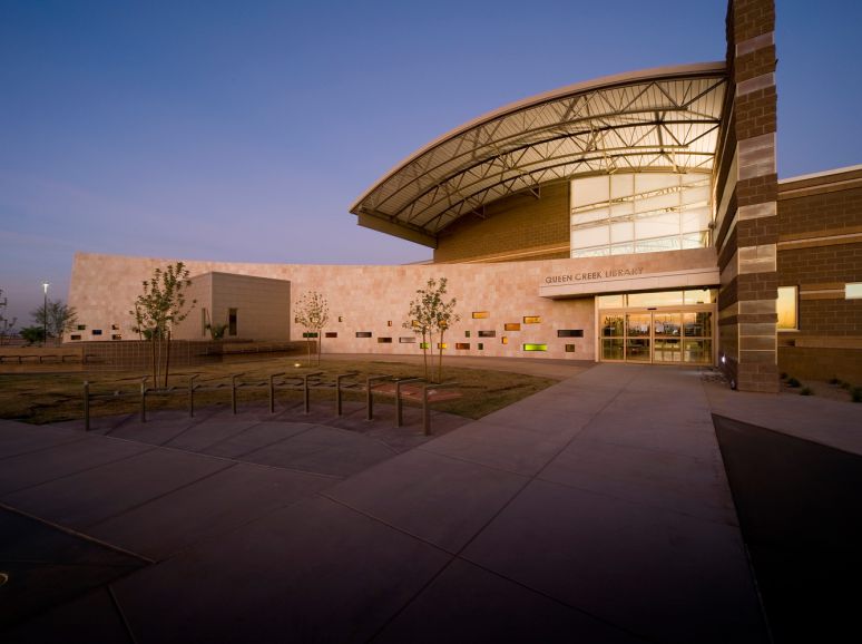 Civic building with a curved roof, lit at dusk