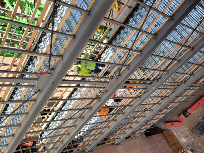 Looking down through the steel floors and stairs of a building under construction